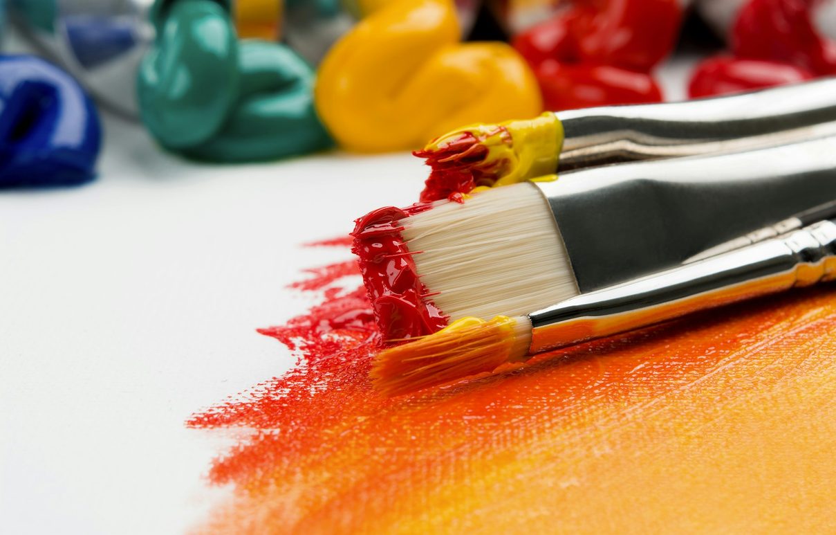 Paintbrushes and tubes of paint on a canvas