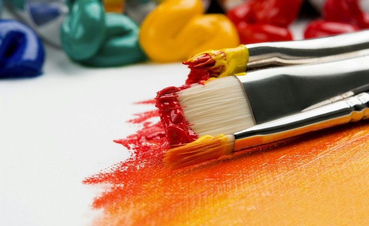 Paintbrushes and tubes of paint on a canvas