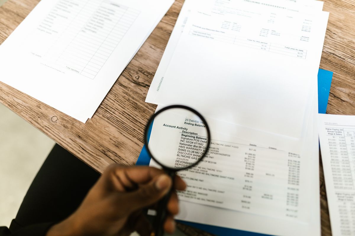 A person using a magnifying glass on a document
