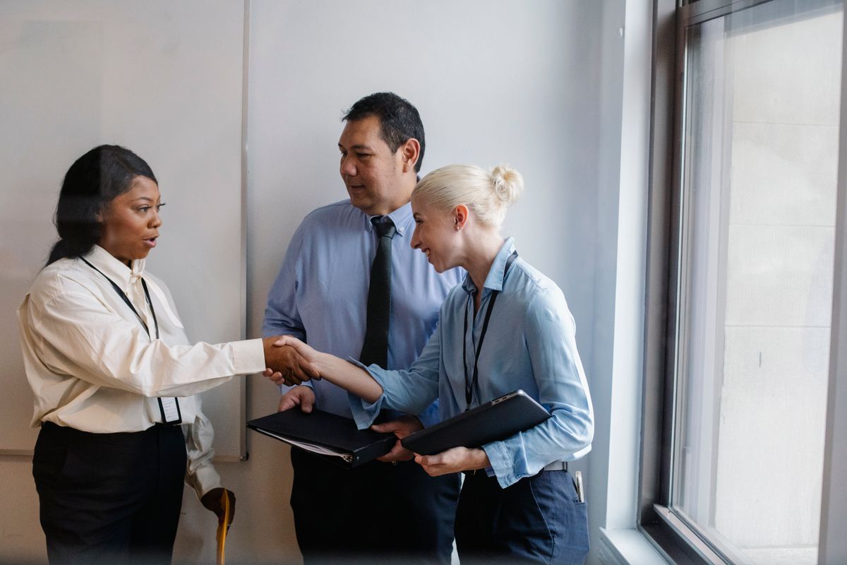 Group of diverse business partners shaking hands in office