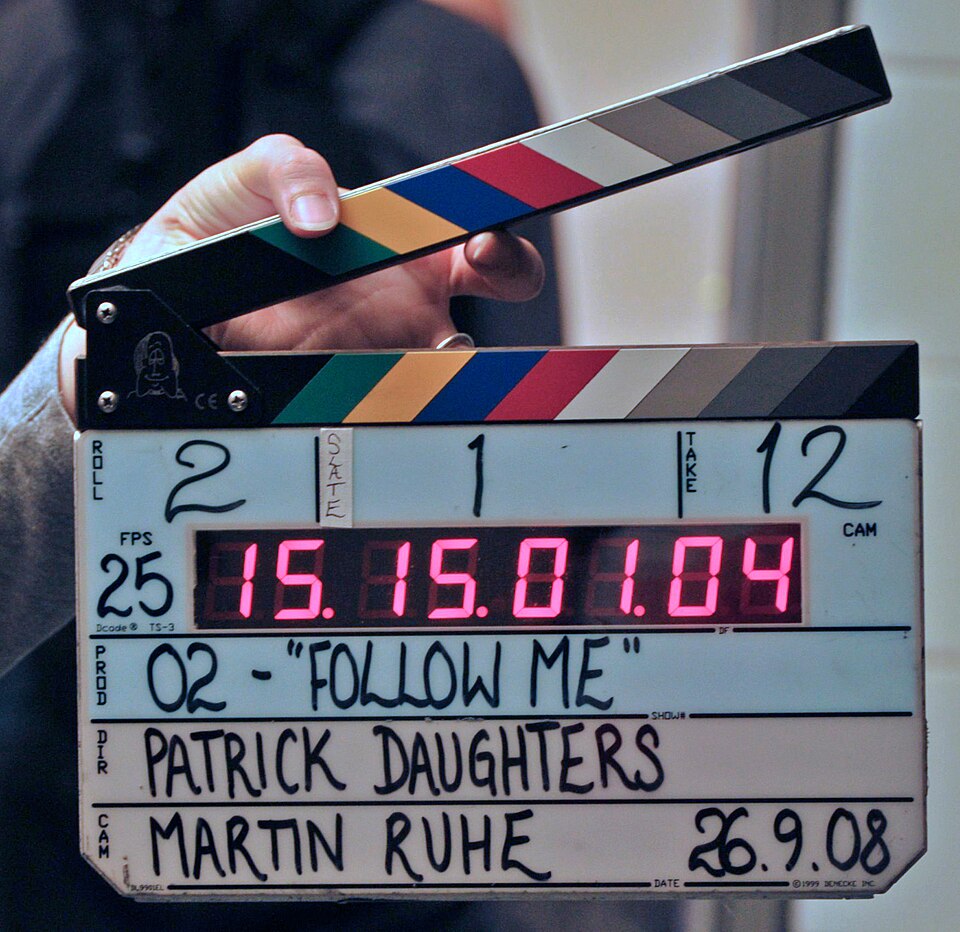 A film clapperboard held in front of a camera
