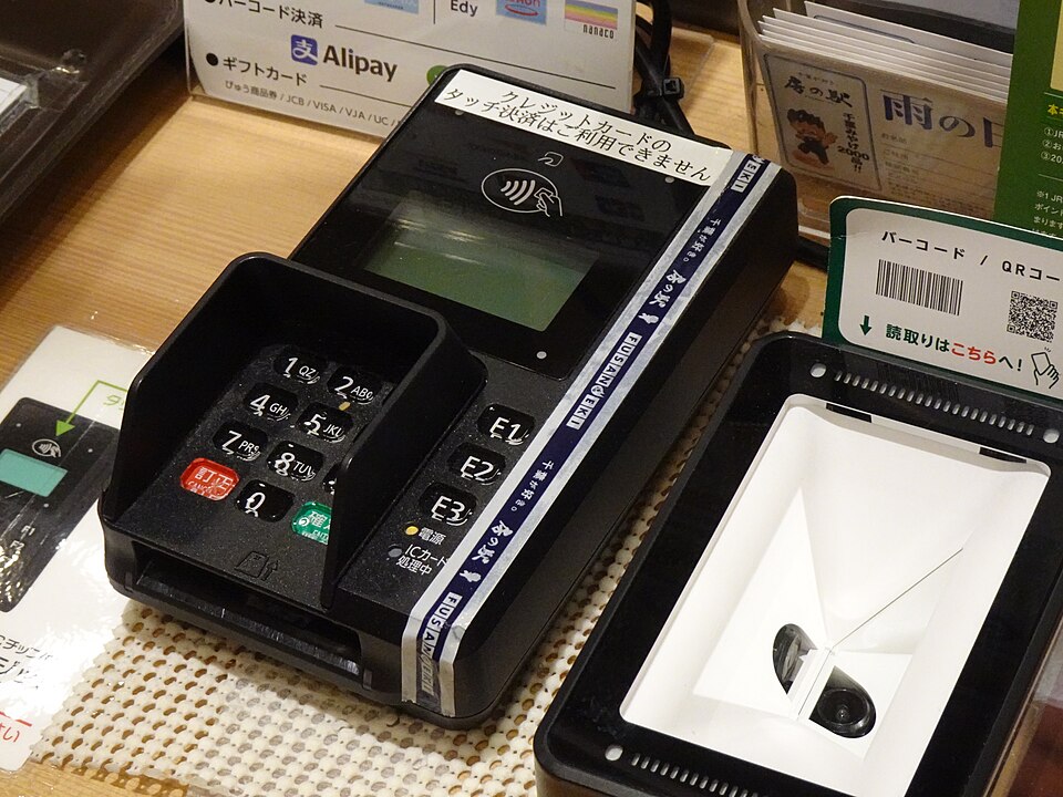 A contactless payment terminal on a shop counter
